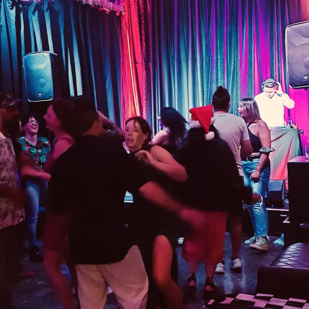 Crowd dancing and partying on the dance floor at Common Room while a DJ plays on stage