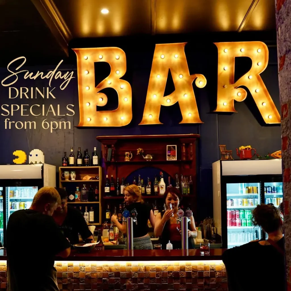 Common Room bar with smiling staff serving customers